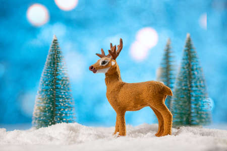 Christmas card. Santa's deer and snowy trees on soft snow on blue background.の写真素材