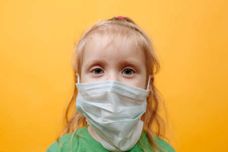 A Small Child In a White Medical Mask. Coronavirus. Protecting Children From The Epidemic. Space for...