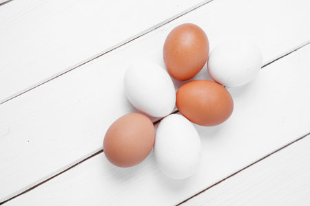 Fresh eggs on wooden white background. top view