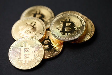 Many gold bitcoins with a single bitcoin in sharp focus floating above them to illustrate bitcoin exchange, mining or blockchain technology for cryptocurrencyの写真素材
