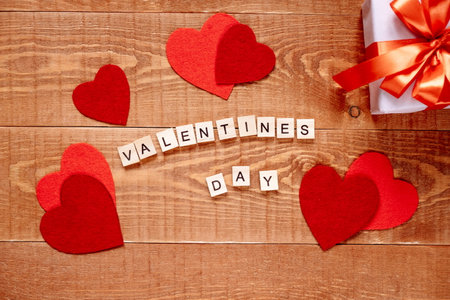 The word Valentines Day. Love on wooden blocks on natural background. Theme of love, heart and gift