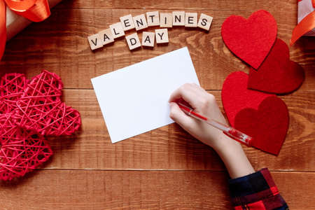 Girl s hand writes card letters holiday love Valentines Dayの写真素材