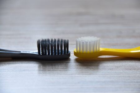 pair soft toothbrushs on the wood table.