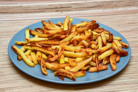 french fries on a blue plate on a wooden background.の写真素材