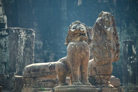 Old stone statue of sacred beast lion. Khmer lion guardians statue of Angkor Wat temple complex in Siem Reap of Cambodia.の写真素材