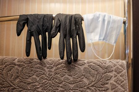 Medical gloves and surgical mask hanging on a dryer for reuse.の写真素材
