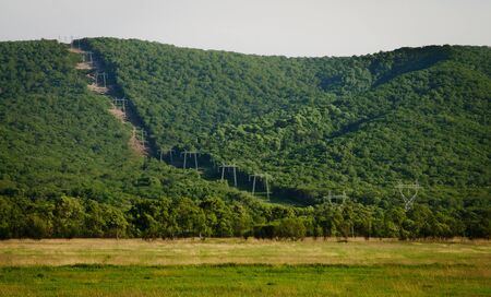 High voltage transmission line pass through the forest and mountain.の写真素材