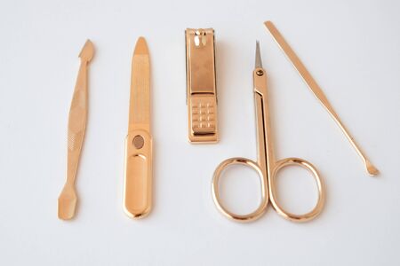 Tools of a manicure set on a white background. Gold color tools.の写真素材