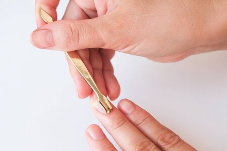 Manicure at home. Female hands use cuticle remover close up. View from above.の写真素材