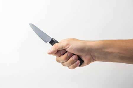 Small kitchen knife in man hand on white background. isolated on white background. Man threaten somebody with knife. Killer concept. Cooking equipment.の写真素材