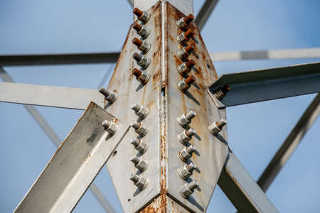 Fragment of a metal construction with bolts and nuts. A High-voltage power transmission tower. Power engineering.の写真素材