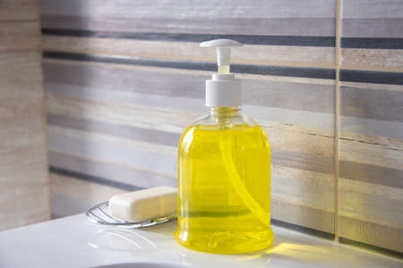 Yellow liquid soap next to hand soap on the bathroom sink.