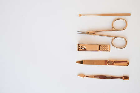Tools of a manicure set on a white background. Gold color tools.
