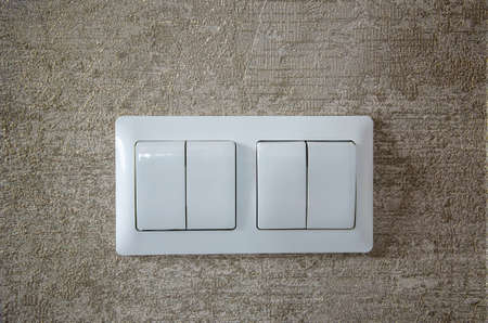 Closeup of two lighting switches on concrete wallpaper background.の写真素材