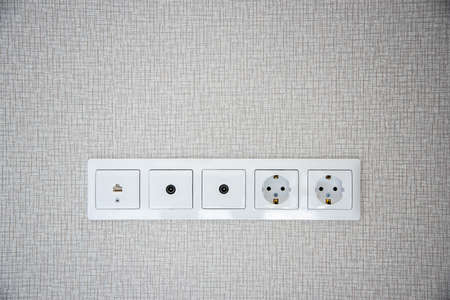 Electric sockets on light wallpaper as a background. Copy space. Home decroration.