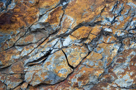 Red grunge background. Rock texture with cracks. Red brown yellow mountain texture closeup. Cracked...