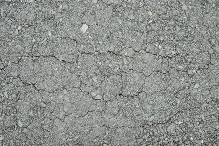 Old worn asphalt road with cracks texture.の写真素材