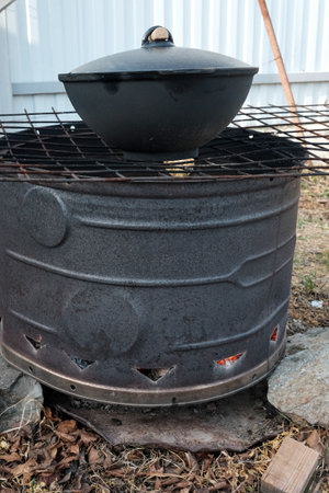 Cooked food a campfire on a camping trip. Camp kitchen, cooking food in the forest on fire. Frying pan on fire. rustic grill for cooking pilaf.の写真素材