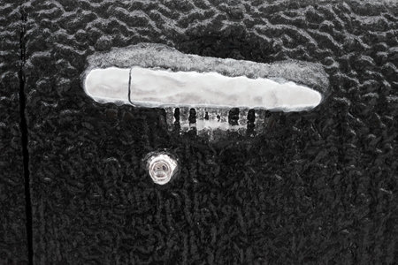 Frozen car door closeup, icicles, ice crystals, jammed lock.の写真素材