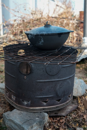 Cooked food a campfire on a camping trip. Camp kitchen, cooking food in the forest on fire. Frying pan on fire. rustic grill for cooking pilaf.の写真素材