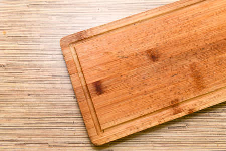 Old chopping board on wooden background top view.の写真素材