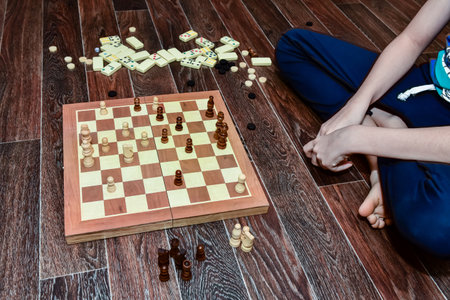 boy plays checkers, chess, dominoes and backgammon. set of board gamesの写真素材