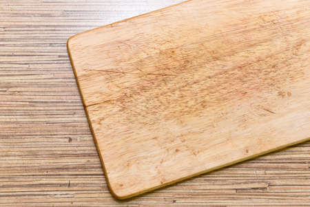 Old chopping board on wooden background top view.の写真素材