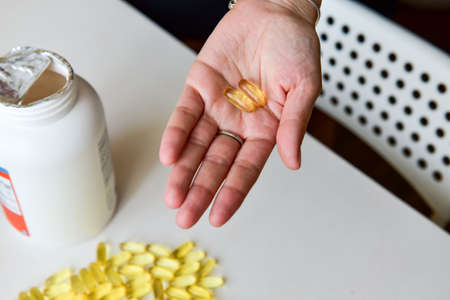 Hand holding fish oil Omega-3 capsules. Medical healthcare, healthy nutrition supplements concept....