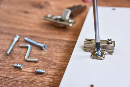 Assembly of cabinet furniture. screwdriver, screws, furniture fittings, door hinges. self-assembly...