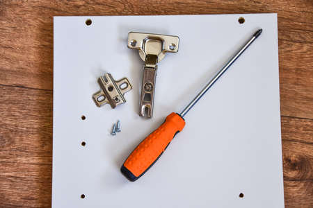 Assembly of cabinet furniture. screwdriver, screws, furniture fittings, door hinges. self-assembly of furniture.の写真素材