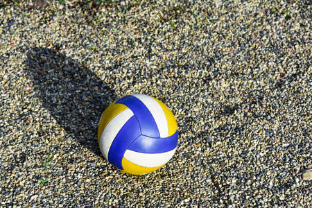 Close up of colored volleyball ball on a sea pebble beach. Summer beach games.の写真素材