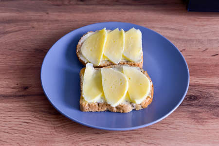 two sandwiches with cheese lie on a plate, close-up photo.の写真素材
