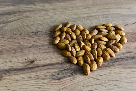 Almonds lying on the table in the form of a heart. Copy space.の写真素材
