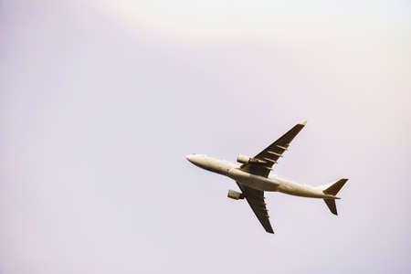 Passenger plane is flying far away against the blue summer and cloudy sky with copy space.の写真素材