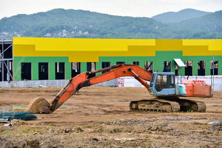 Excavator on earthworks at construction site. Backhoe on earthmoving and foundation work. Heavy...