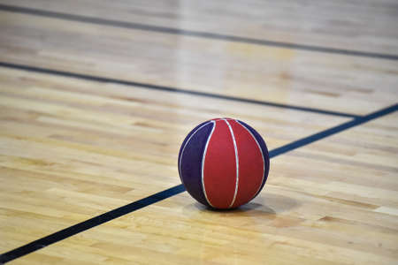 Basketball ball on wooden court background in the gym.の写真素材