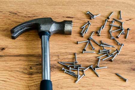 Metal hammer with nails on a wooden table. Close up. Carpenter concept.の写真素材