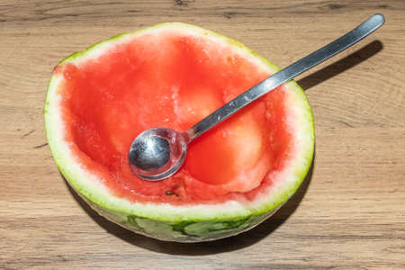 empty half of watermelon after eating with a spoon close-up.の写真素材