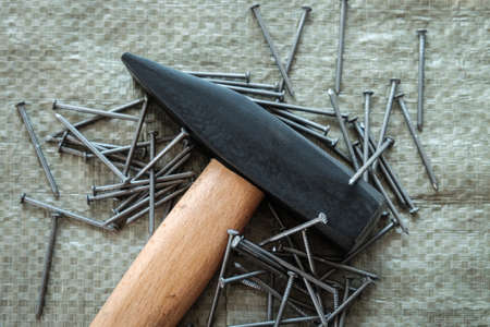 hand tools, old tools. hammer and nails on a construction surface, close-up.
