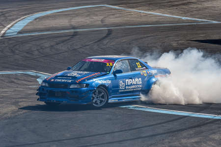 VLADIVOSTOK, RUSSIA - OCTOBER 02: Car drift, Sports car wheel drifts and a lot of smoke on the track. Russian drift show RDS without borders on October 02, 2021.のeditorial素材
