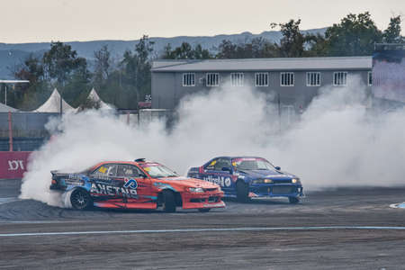 VLADIVOSTOK, RUSSIA - OCTOBER 02: Two Cars drift, Sports cars wheel drifts and a lot of smoke on the track. Russian drift show RDS without borders on October 02, 2021.のeditorial素材