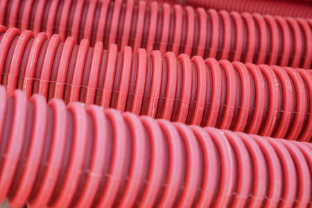 Red flexible corrugated pipe close-up, used for protecting cables in electrical installation.の写真素材