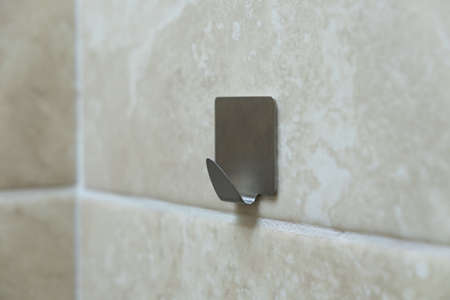 Metal hook for clothes on a tile. Wall hook for towels.の写真素材