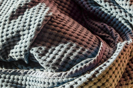 Close up view of gray cotton fabric waffle kitchen towel texture with harsh shadows. Backgrounds and textures.の写真素材