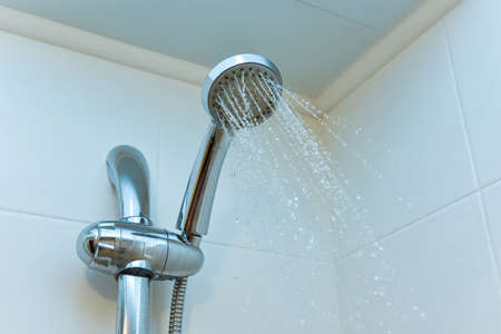 shower head in bathroom with water drops flowing.の写真素材