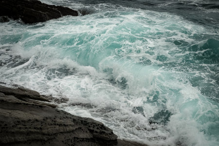 sea waves with splashes and foam wash over the rocky stones.