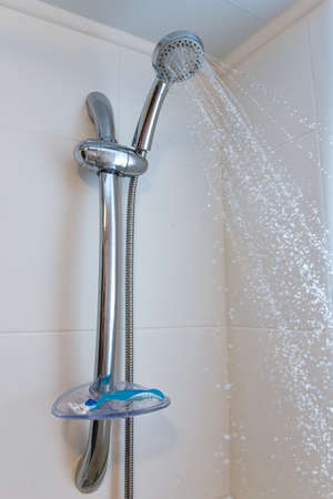 shower head in bathroom with water drops flowing.の写真素材