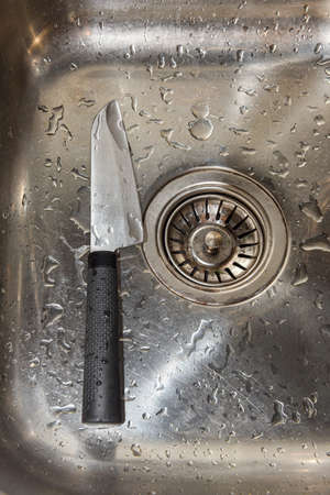 knife in the sink among drops of water.の写真素材