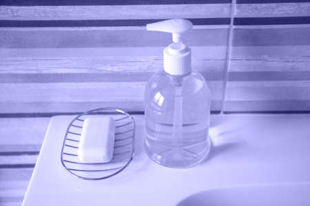 liquid soap next to hand soap on the bathroom sink. photo toned in the color of the year very peri.の写真素材