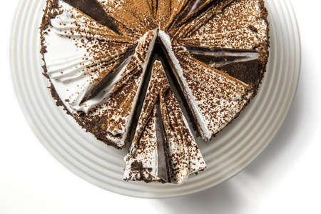 cake with chocolate, sprinkled with chocolate chips, on a tray on a white background with a cut piece. top view.の写真素材